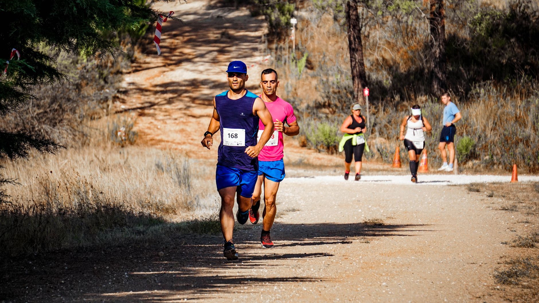 Coureurs progressant sur un chemin de terre balisé pendant une course nature