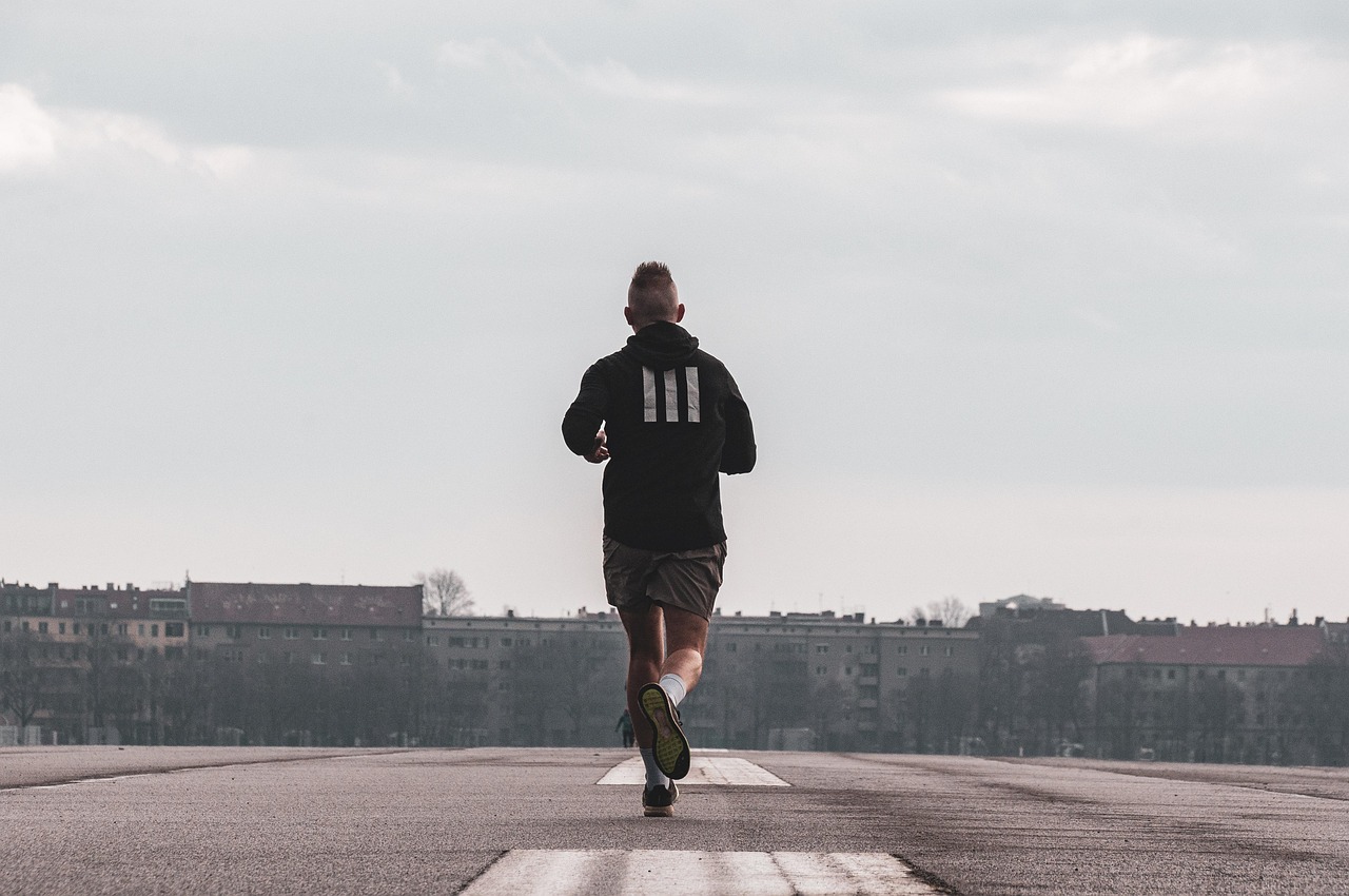 Un coureur en tenue sportive sur une voie urbaine